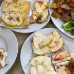 Teller mit verschiedenen Snacks, u.a. Knäckebrote mit Apfel und Zimt.