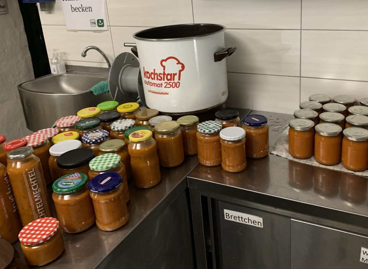 Auf der Küchentheke stehen Einmachgläser mit Tomatensoße, daneben ein Schnellkochtopf
